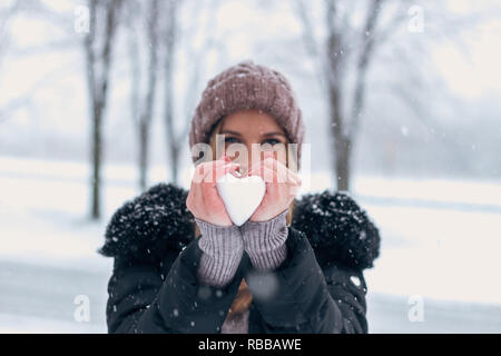 Frau mit Schnee im Herzen Form. Stockfoto