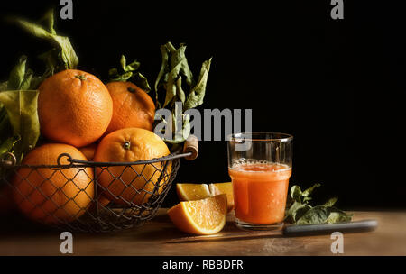 Orangen Saft auf hölzernen Tisch mit schwarzem Hintergrund: Detailansicht Stockfoto