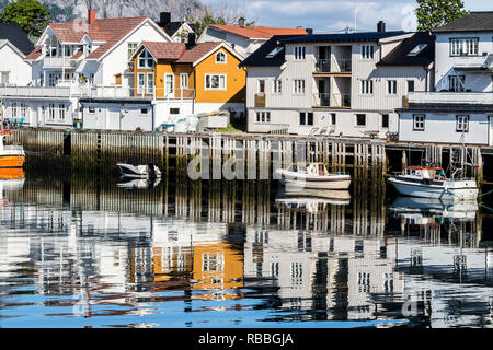 Pier am Hafen in Henningsvær, Reflexionen von Holzhäusern im ruhigen Wasser, Austvagöy, Lofoten, Norwegen Stockfoto