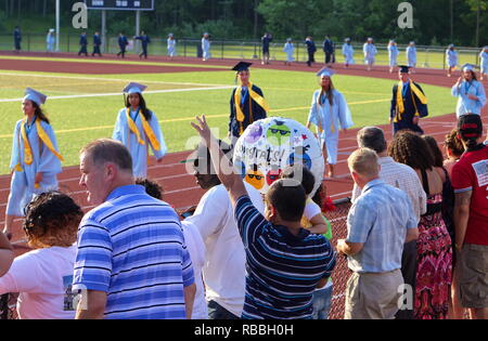 Middletown, CT USA. Aug 2013. Junge winken und jubeln auf ein Geschwister stolz Abitur. Stockfoto