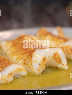 Drei gebackene gegrillte Fisch Filets in Butter auf dem Teller dampfender auf Restaurant Grill. Makro geschossen zu schließen. Stockfoto