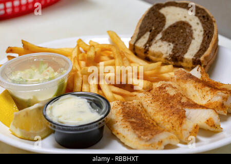 Bar essen: gebackene Fischplatte mit Pommes frites, marmoriert Roggen Brot, Pommes, Krautsalat, Zitrone Keile und Sauce Tartar. Stockfoto