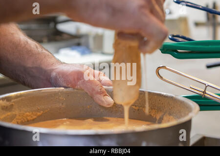 Der Küchenchef bereitet ein typischer Freitag Nacht fisch braten in Wisconsin. Tauchen Fischfilets im Bierteig vor dem Ablegen in einen heißen Fritteuse. Stockfoto