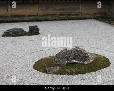 Die berühmten trockenen Rock Garden am Ryoan-ji Zen-buddhistischen Tempel in Kyoto; mit sorgfältig gesetzten Steinen, Moos und geharkter Kies gegen einen Ton Wand Stockfoto