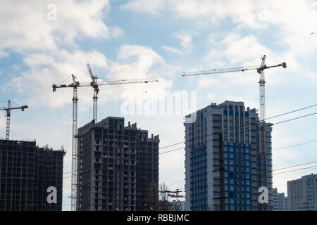Bau von mehrgeschossigen Gebäuden mit Hilfe von vier Turmdrehkrane. Stockfoto