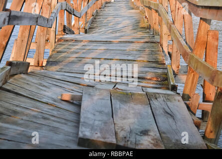 Detail eines deformierten hölzerne Brücke über einen kleinen Fluss Stockfoto