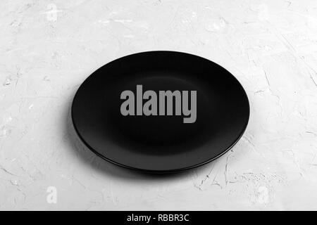 Blick von oben auf die Matte runde Leere schwarze Platte auf dunklen Zement Hintergrund Kopie Platz für Sie entwerfen. Perspektive betrachten. Stockfoto