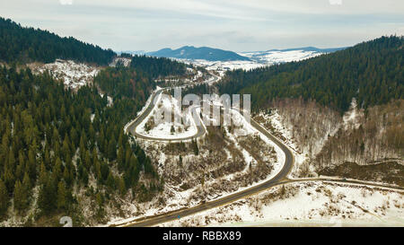 Straße Serpentine im Winter verschneite Berglandschaft. Antenne Blick auf der Straße bis zum Horizont. Karpaten, Beskiden Bereich Stockfoto