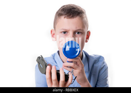 Junge erklärt, die Art und Weise, wie mit einem blauen Megafon und ein Kompass in der Hand vor einem weißen Hintergrund Stockfoto