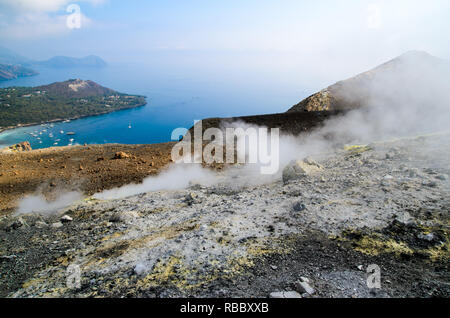 Rauch und Dampf aus dem Krater des Vulkan auf der Insel Vulcano Äolischen Inseln, Sizilien, Italien. Blaue Meer im Hintergrund. Stockfoto