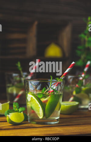 Frischen alkoholfreien Cocktail mit Kalk, Eis und Minze, mojito Cocktail in einer Bur auf einem rustikalen Tisch, selektiver Fokus, flacher Tiefe des Feldes. Stockfoto