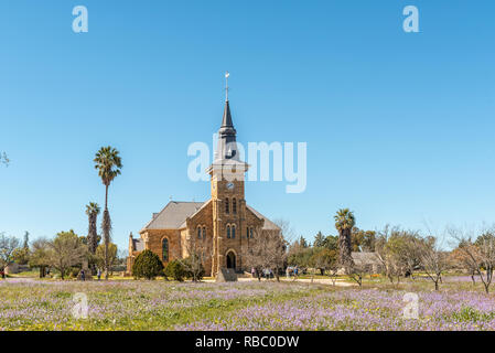 NIEUWOUDTSVILLE, SÜDAFRIKA, 29. AUGUST 2018: die Niederländische Reformierte Kirche in Nieuwoudtville in der Northern Cape Provinz. Menschen und wilden Blumen Stockfoto