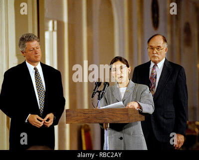 Washington DC. USA, August 10, 1993 Präsident William Jefferson Clinton hört auf Neu vereidigten Associate Gerechtigkeit Ruth Bader Ginsberg, wie sie Adressen Mitglieder des Weißen Hauses Korps im Osten. Hinter ihr steht, des Obersten Gerichtshofs der Vereinigten Staaten William Rehnquist, der gerade die Vereidigung Amtseid auf Gerechtigkeit Ginsberg durchgeführt habe. Credit: Mark Reinstein/MediaPunch Stockfoto