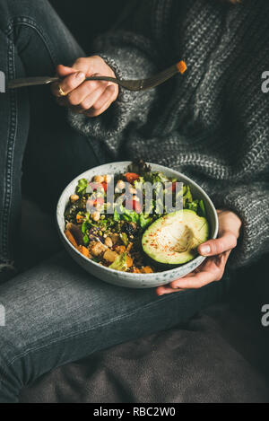 Frau mit Schüssel mit Salat, Avocado, Bohnen und Gemüse Stockfoto