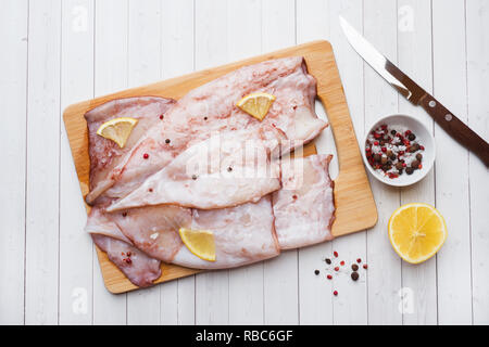 Raw squid Karkasse mit Gewürzen und Zitrone zum Kochen auf dem Tisch bereit Stockfoto