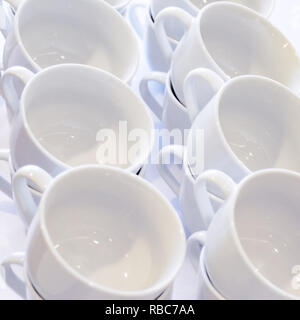 Leere weiße Tassen gestapelt auf dem Tisch. Tee oder Kaffee Catering Services im Hotel, Event, Konferenz, Tagung oder Hochzeit. Ansicht von oben. Stockfoto