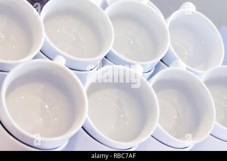 Leere weiße Tassen gestapelt auf dem Tisch. Tee oder Kaffee Catering Services im Hotel, Event, Konferenz, Tagung oder Hochzeit. Ansicht von oben. Stockfoto