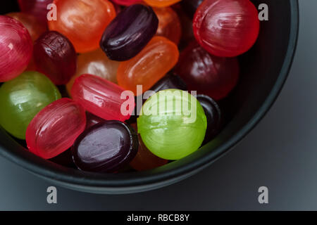 Die bunten Süßigkeiten sind in einem schwarzen eine Schüssel. Stockfoto