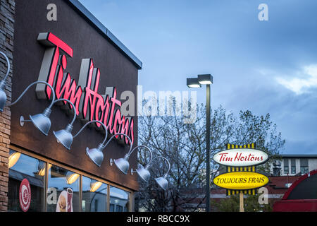 MONTREAL, KANADA - 6. NOVEMBER 2018: Tim Hortons Logo vor einem ihrer Restaurants in Quebec mit ihren Slogan in französischer Sprache in den Hintergrund. Ti Stockfoto