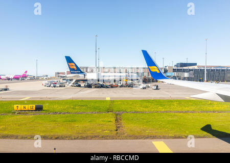 Keflavik, Island - 20. Juni 2018: Icelandair blauen Flugzeug auf der Piste mit Aussicht vom Fenster hohen Winkel in internationalen Flughafen geparkt, Sonnig da Stockfoto