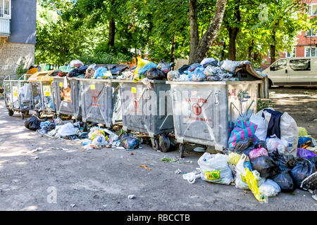 Riwne, Ukraine - Juli 4, 2018: schmutzige Müllcontainer überfüllt mit Müll Müll auf den Boden in der ukrainischen Stadt mit kyrillischen Zeichen, Kunststoff Einkaufstüten Stockfoto