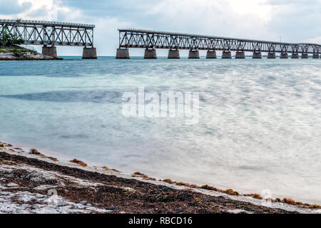 Alte Seven Mile Bridge Landschaft der Florida Keys lange Belichtung Wasser Atlantik und Eisenbahn Straße in Bahia Honda Strand bei Sonnenuntergang am Abend Stockfoto