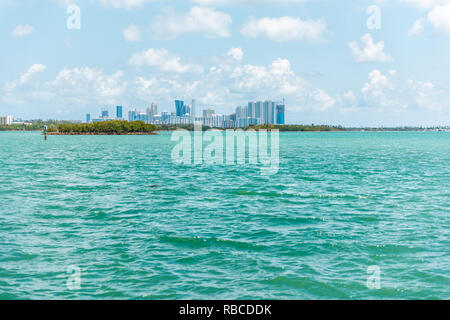 Sonnigen Tag in Bal Harbour, Miami Florida mit Hellgrün türkis Meer Biscayne Bay Intracoastal Wasser und Stadtbild Skyline von Sunny Isles Beach Stockfoto