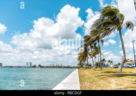 Bal Harbour, USA - Mai 8, 2018: Die Landschaft oder das Stadtbild in Miami Florida mit Green Ocean Biscayne Bay und Reihe von Palmen auf der Broad Causeway Stockfoto