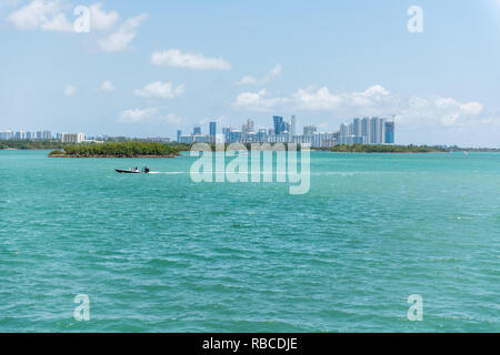 Boot in Bal Harbour, Miami Florida mit Hellgrün türkis Meer Biscayne Bay Intracoastal Wasser und Stadtbild Skyline von Sunny Isles Beach Stockfoto