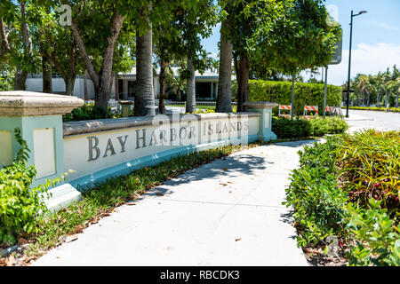 Bal Harbour, USA - Mai 8, 2018: Bay Harbor Islands in Miami Florida mit grünen Pflanzen und Bürgersteig durch Zeichen Eingang zur Stadt Stockfoto
