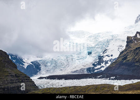 Detailansicht auf Skaftafell National Park, Island Blue Ice snow Gletscherzungen mit felsigen Klippen und Nebel Nebel stürmischen bedeckt Berge Stockfoto