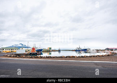 Höfn, Island - 15. Juni 2018: Kleines Fischerdorf Hafen mit Booten und ruhigen fjord Wasser in Hornafjördur mit leeren Straße Stockfoto