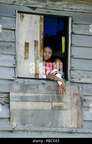 Kinder, die auf der Suche Fenster der Hütte in stelze Village, South China Sea in der Nähe von Kota Kinabalu, Sabah (Borneo), Malaysia Stockfoto