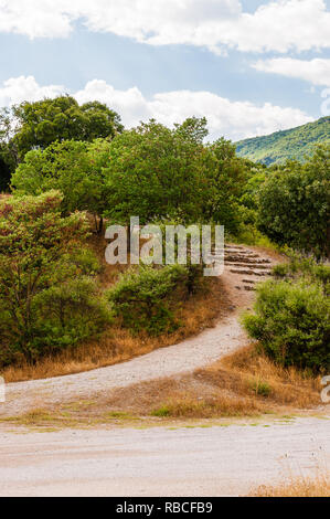 Malerischer Blick auf die Geschwungenen Gehweg mit steinernen Treppe, die zu den hohen überwachsen mit mediterraner Flora Berge auf dem Weg von Thessalonik Stockfoto