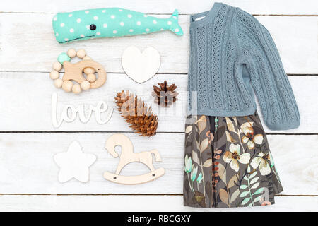 Kinder Kleidung und Spielzeug auf einer hölzernen Hintergrund. Flach Stockfoto