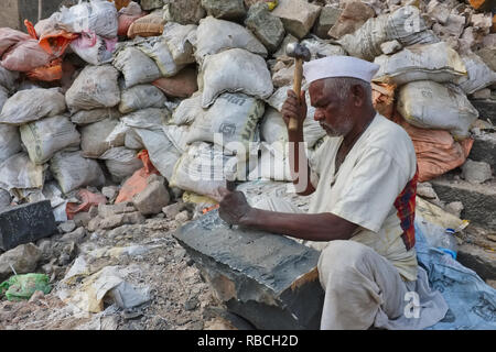 Ein Steinmetz in Mumbai, Indien, schnitzt heraus ein Stein aus einem Stück Granit; Arbeiten w/o Schutz, viele Steinmetze Risiko schwarze Lunge- und Augenverletzungen Stockfoto