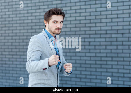 Porträt von Ernst gut aussehender bärtiger Mann im lässigen Stil stehen in Boxen Geste und Kamera mit Zorn Gesicht in attack Position. indoor s Stockfoto