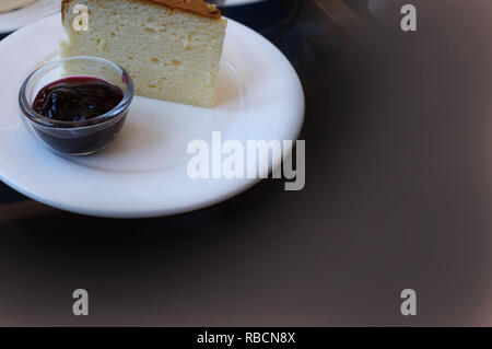 Ein Stück Käsekuchen und Himbeersauce. Stockfoto