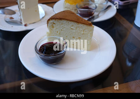 Ein Stück Käsekuchen und Himbeersauce. Stockfoto