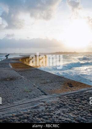 Große Wellen brechen auf gewölbten Stein Pier am stürmischen Wetter mit lebendigen Sonnenuntergang, große Flut, Saint Malo, Frankreich. Stockfoto