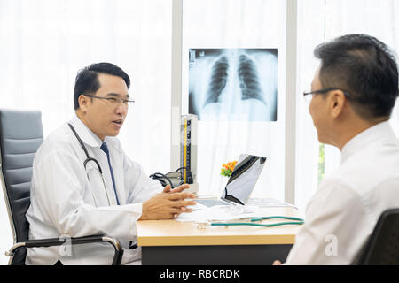 Professionelle Arzt erklären über x-ray Ergebnis zu Patienten in der Arztpraxis Krankenhaus Stockfoto