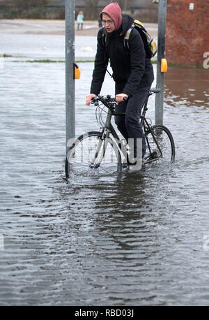 Wismar, Deutschland. 09 Jan, 2019. Ein Radfahrer fährt durch eine überflutete Kreuzung. Eine Sturmflut ist wieder in vielen Orten an der Ostsee im Nordosten erwartet. Die Hamburger maritime Wetterdienst hat ein starker Wind Warnung für die Ostseeküste. Credit: Jens Büttner/dpa-Zentralbild/dpa/Alamy leben Nachrichten Stockfoto