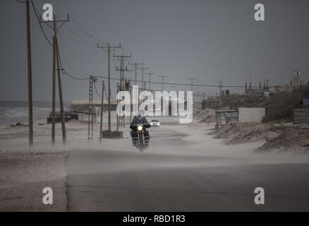 Gaza, Gaza, Palästina. 8 Jan, 2019. Palästinenser Spaziergang auf der Strandpromenade Gehweg während ein Staubsturm in Gaza Stadt. Credit: Mahmoud Issa/Quds Net News/ZUMA Draht/Alamy leben Nachrichten Stockfoto