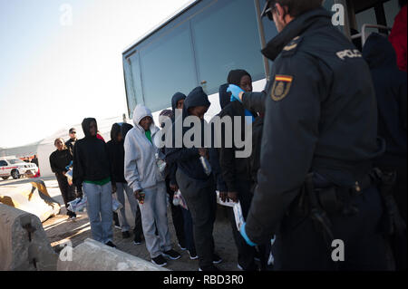 Malaga, Spanien. 9 Jan, 2019. Einen Polizisten gesehen, der auf das Migranten Frauen, wie sie warten, einen polizeiwagen nach Ihrer Ankunft im Hafen von Málaga in Spanien Maritime Rescue Service 188 Migranten an Bord Jollen auf der Alboran See gerettet und brachte sie nach Malaga Hafen, von wo aus sie durch das Spanische Rote Kreuz unterstützt wurden. Credit: Jesus Merida/SOPA Images/ZUMA Draht/Alamy leben Nachrichten Stockfoto