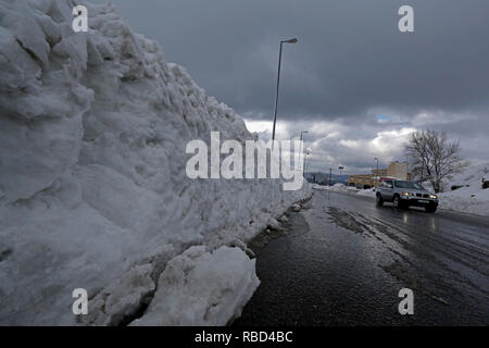 (190109) - Beirut, Januar 9, 2019 (Xinhua) - ein Auto fährt auf einer Landstraße mit schweren Schnee auf beiden Seiten in einer bergigen Gegend im Osten Beirut, Libanon, Jan. 9, 2019. Einen grossen Sturm, betitelt Norma, hit Libanon ab 14.01.6, 14.01.9, und brachte schwere Regen und Schnee zu vielen Gebieten des Landes. (Xinhua / Bilal Jawich) Stockfoto