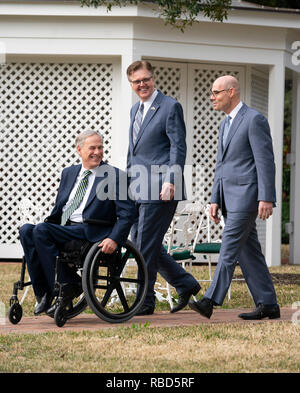 Texas politische Führer reg. Greg Abbott (im Stuhl), Leutnant. Dan Patrick, und Sprecher des Repräsentantenhauses Dennis Bonnen Spaziergang auf dem Gelände der Texas Governor's Mansion in Austin vor der Presse zu Beginn der 86. Legislaturperiode. Stockfoto