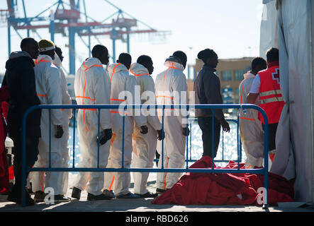 Migranten in der Warteschlange werden gesehen, warten in einem Zelt des spanischen Roten Kreuzes nach Ihrer Ankunft im Hafen von Malaga ein. Spaniens Maritime Rescue Service gerettet 188 Migranten an Bord Jollen auf der Alboran See, und brachte sie nach Malaga Hafen, von wo aus sie durch das Spanische Rote Kreuz unterstützt wurden. Stockfoto