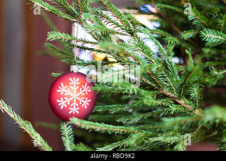 Ornamente auf grüne Zweige lebender Weihnachtsbaum und Fernsehgerät auf den Hintergrund zu Hause indoor Stockfoto