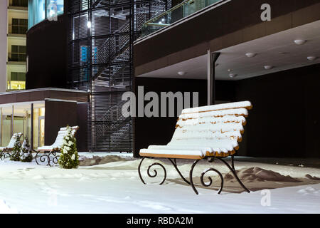 Modernes Gebäude aus Glas und Beton inmitten der verschneiten Winterlandschaft bei Nacht. Schwere nördlichen Winter und Schnee. Verschneite Holzbänken. Narva-Joesuu Stockfoto