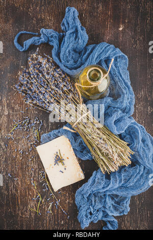 Ätherischen Lavendelöl, chemische Lavendelblüten, pflanzliche Seife und Badesalz. Ansicht von oben. Stockfoto